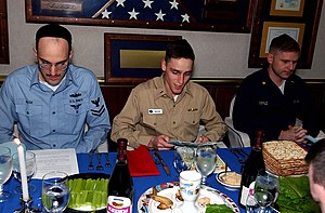 US Navy 030417-N-0923G-022 Lt. j.g. Derek Cedars reads a prayer verse during the Jewish Passover celebration.jpg